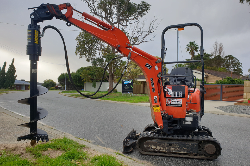 Mini excavator with auger attachment