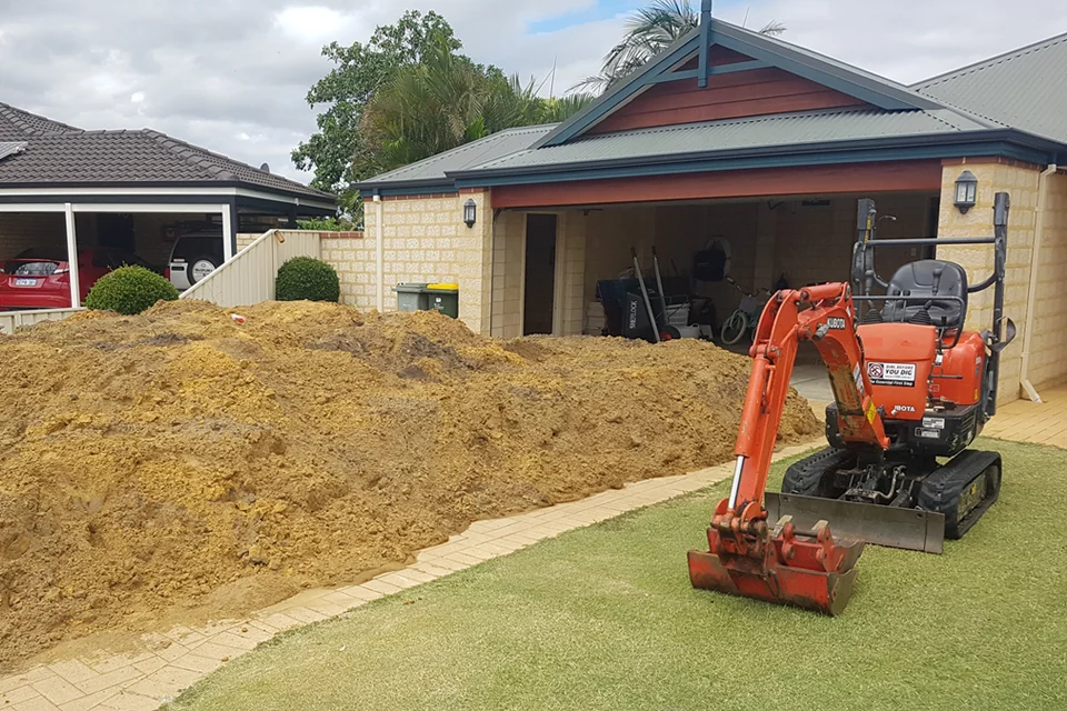 mini-excavator-pile-sand Mini excavator excavating sand.