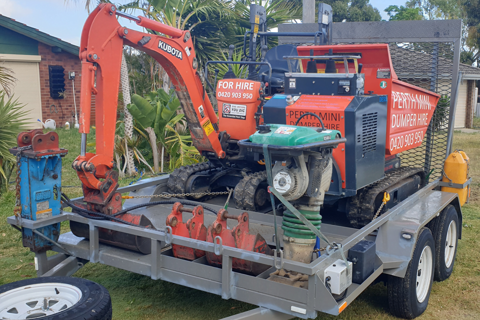 Trailer loaded with mini excavator and mini dumper